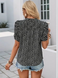 Détail d'une blouse à imprimé floral noir et blanc avec manches bouffantes et col élastique