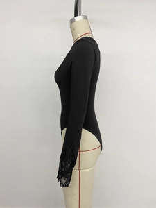 Close-up of elegant black bodysuit featuring intricate floral lace cuffs and ribbed knit fabric