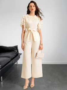 Close-up of cream white lace patchwork and bow tie waist on this summer jumpsuit