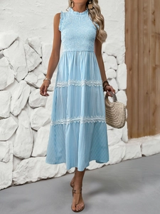 Close-up of lace trim and smocked bodice on a striped summer maxi dress in light blue