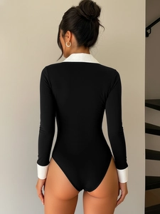 Detailed back view of a slim fit black bodysuit with contrast white collar and wide cuffs