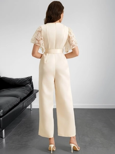 Detail of elegant lace short sleeves and belted high waist on a beige jumpsuit