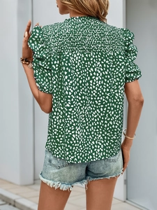 Détail de la texture smockée et des manches bouffantes sur une chemise d'été à cœurs