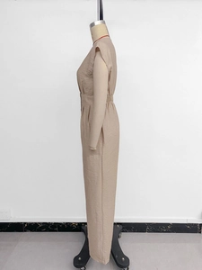 Detail of beige sleeveless jumpsuit with textured fabric and elegant waist pleats