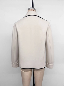 Rear view of cropped oatmeal wool jacket with black contrast piping and lapel collar