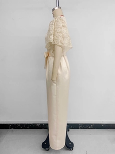 Detailed side view of champagne lace jumpsuit with satin bow and floral cape sleeves