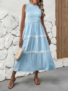 Detailed view of white lace trim on a blue striped smocked maxi dress for summer