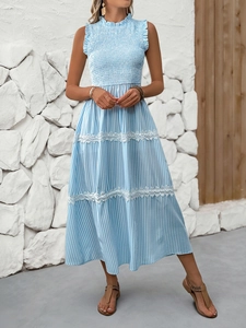 Close-up of white lace trim and smocked bodice details on a blue striped maxi dress