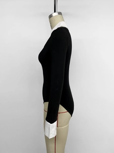 Detail view of the black and white contrast collar and cuffs on the bodysuit