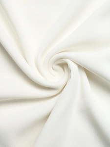 Detailed macro view of white ribbed knit fabric texture with soft draped mesh layering