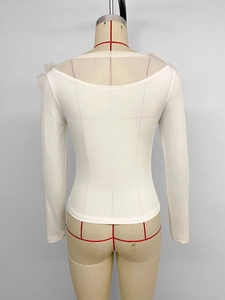 Detail of white long sleeve top featuring tiered ruffle shoulders and ribbed fabric texture