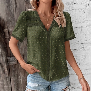 Macro view of olive green Swiss dot fabric and V-neck hollow lace detail on a women shirt