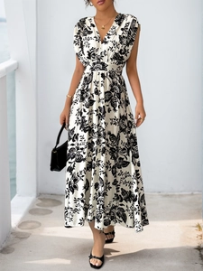 Close-up of deep V-neckline and elegant black floral print on a pleated sleeveless dress