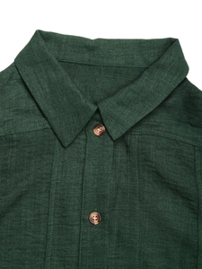 Detail of dark green textured shirt dress featuring lapel collar and brown wooden buttons