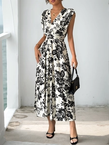 Detailed view of deep V-neck and floral pattern on elegant sleeveless pleated maxi dress
