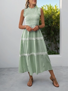 Detailed view of the green and white striped summer dress featuring wavy lace trim on the hem