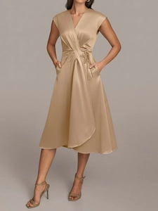 Détail d'une robe midi en satin doré champagne avec col en V croisé et ceinture à nouer
