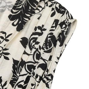 Macro shot of fine pleated fabric details with elegant black floral prints on cream base