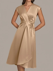 Détail de la robe élégante en satin champagne avec col en V et ceinture à la taille