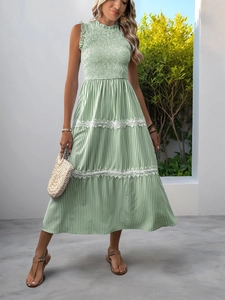 Detail of green striped dress featuring delicate white lace tiers and smocked texture