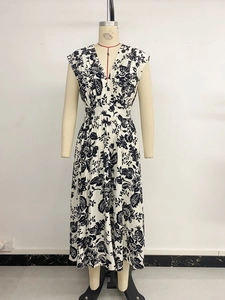 Macro detail of V-neckline with pleated fabric and floral print on this long dress