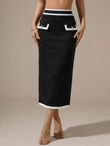 Close-up of black high-waisted midi skirt with white contrast trim and gold buttons