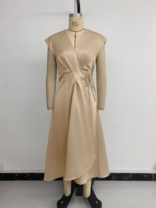 Détail d'une robe élégante en satin champagne avec col en V et taille nouée sur le côté