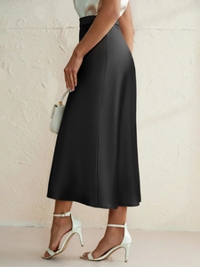Detail view showing smooth black satin fabric texture and elegant high waist on midi skirt