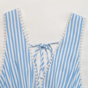 Detail von blau gestreiftem V-Ausschnitt Kleid mit weißen Bommel-Spitzen und Schleife