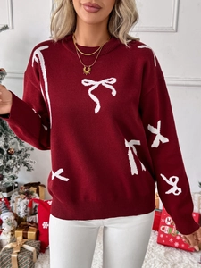 Macro detail of wine red knit sweater featuring white ribbon bow jacquard patterns