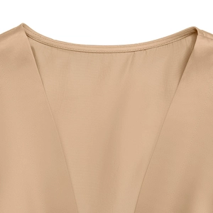 Détail du décolleté en V sur une robe en satin champagne avec coutures délicates