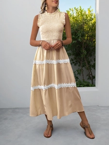 Detailed view of yellow striped dress with smocked bodice and lace-trimmed tiered hem