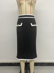 Detail of high-waist knit skirt with white contrast trim and gold buttoned pockets