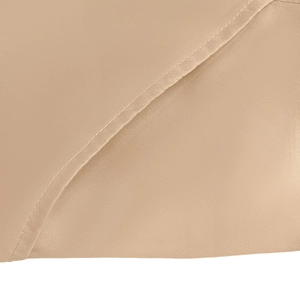 Gros plan de la texture du satin beige et détails de couture à aiguille unique