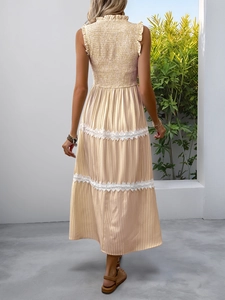 Detail view of the back of a striped vacation dress with white lace trim and smocked waist