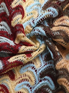 Detailed macro view of colorful zigzag crochet knit fabric with hollow texture