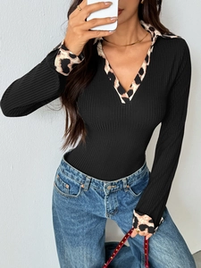 Detailed view of black ribbed knit bodysuit with leopard print collar and sleeve cuffs