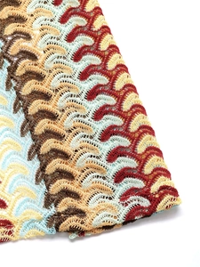 Detailed macro shot of bohemian multicolored crochet fabric with wavy striped patterns