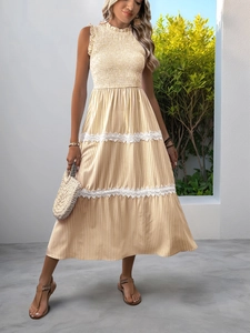 Detail of summer striped maxi dress with delicate white lace trim and pleated tiers