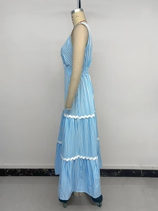 Détail d'une robe longue à rayures bleues et blanches avec jupe à volants et bordure en dentelle
