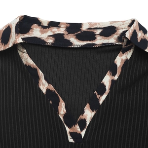 Detail of V-neckline featuring leopard print trim and black ribbed knit fabric