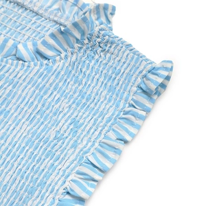 Detail of blue and white striped smocking fabric with delicate ruffle lace trim