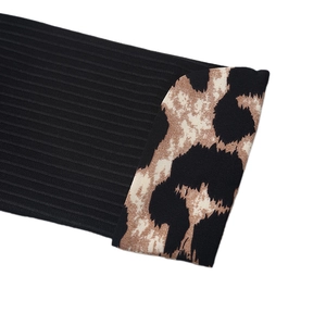 Detail of black ribbed knit fabric with leopard print sleeve cuff on a V-neck bodysuit