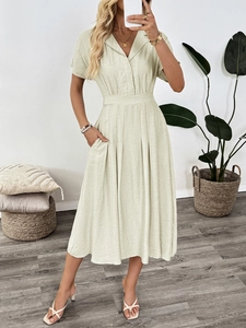 Detail view of the elegant pleated skirt and side pocket on this sage green midi dress