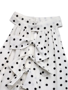 Détail de l'encolure de la robe à pois avec design évidé et trois nœuds décoratifs