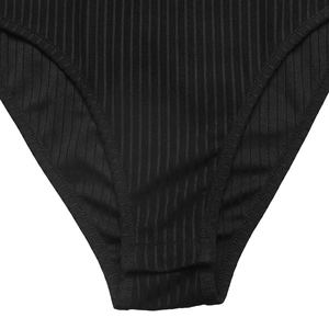 Detail of black ribbed knit bodysuit showing double-stitched hem and fabric texture