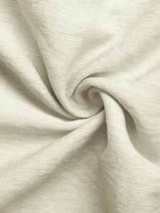 Detailed macro view of soft cream knit fabric texture with elegant draped folds