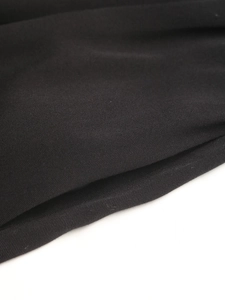Gros plan d'un tissu de robe noir de haute qualité avec texture sergée élégante et beau drapé