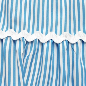 Detail of blue striped summer fabric featuring elegant white wavy ric-rac trim texture