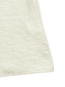 Close-up of beige cotton-linen fabric texture with neat flat-seam hem on shirt dress